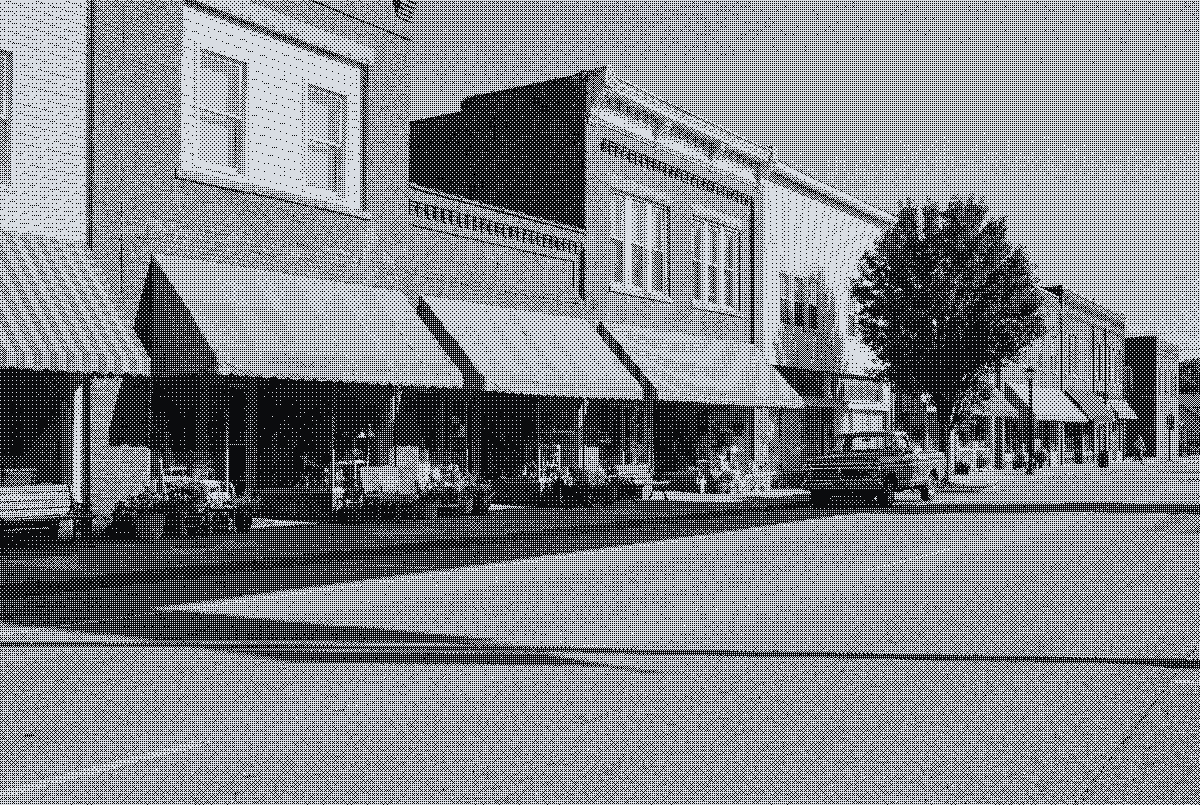 A small-town main street of shops with offices upstairs, printed in dots